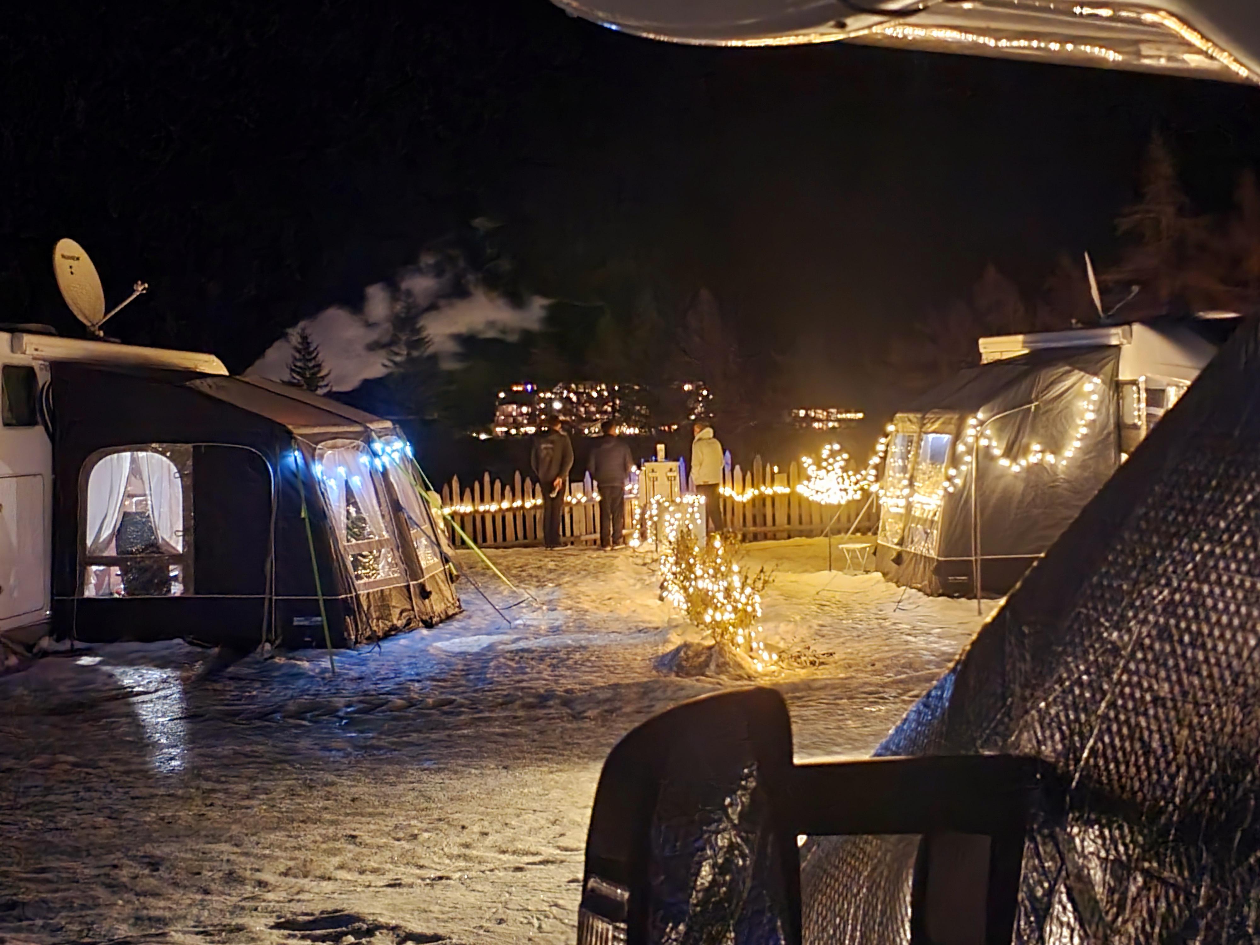 Auf dem Wintercampingplatz haben es sich manche Urlauber weihnachtlich eingerichtet und treffen sich vor dem Camper zum Glühwein.