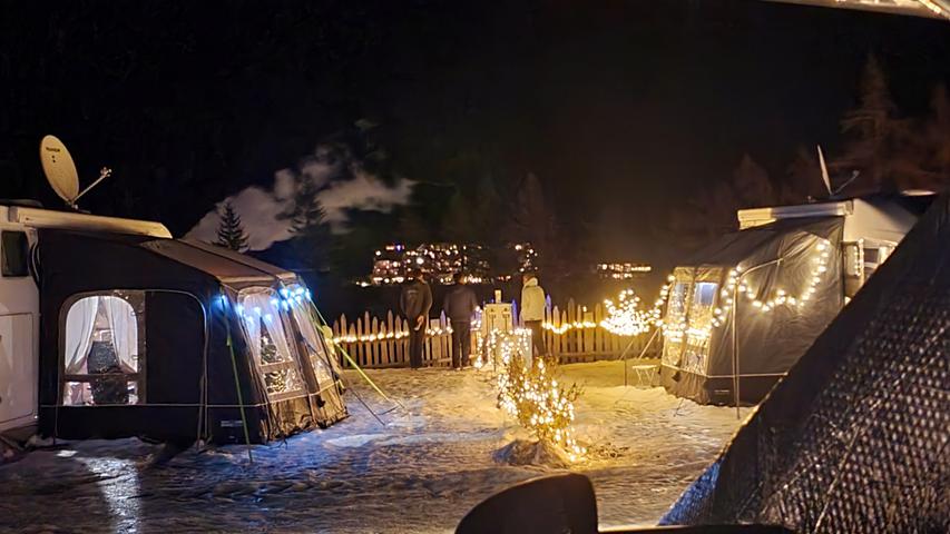 Auf dem Wintercampingplatz haben es sich manche Urlauber weihnachtlich eingerichtet und treffen sich vor dem Camper zum Glühwein.