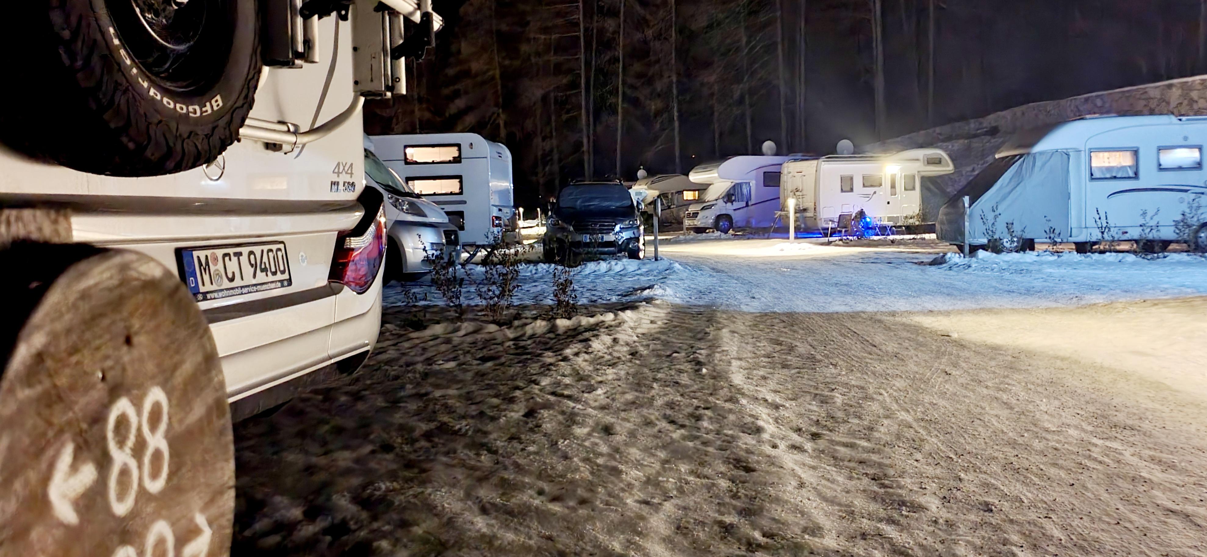 Schnee liegt zwischen den Fahrzeugen.