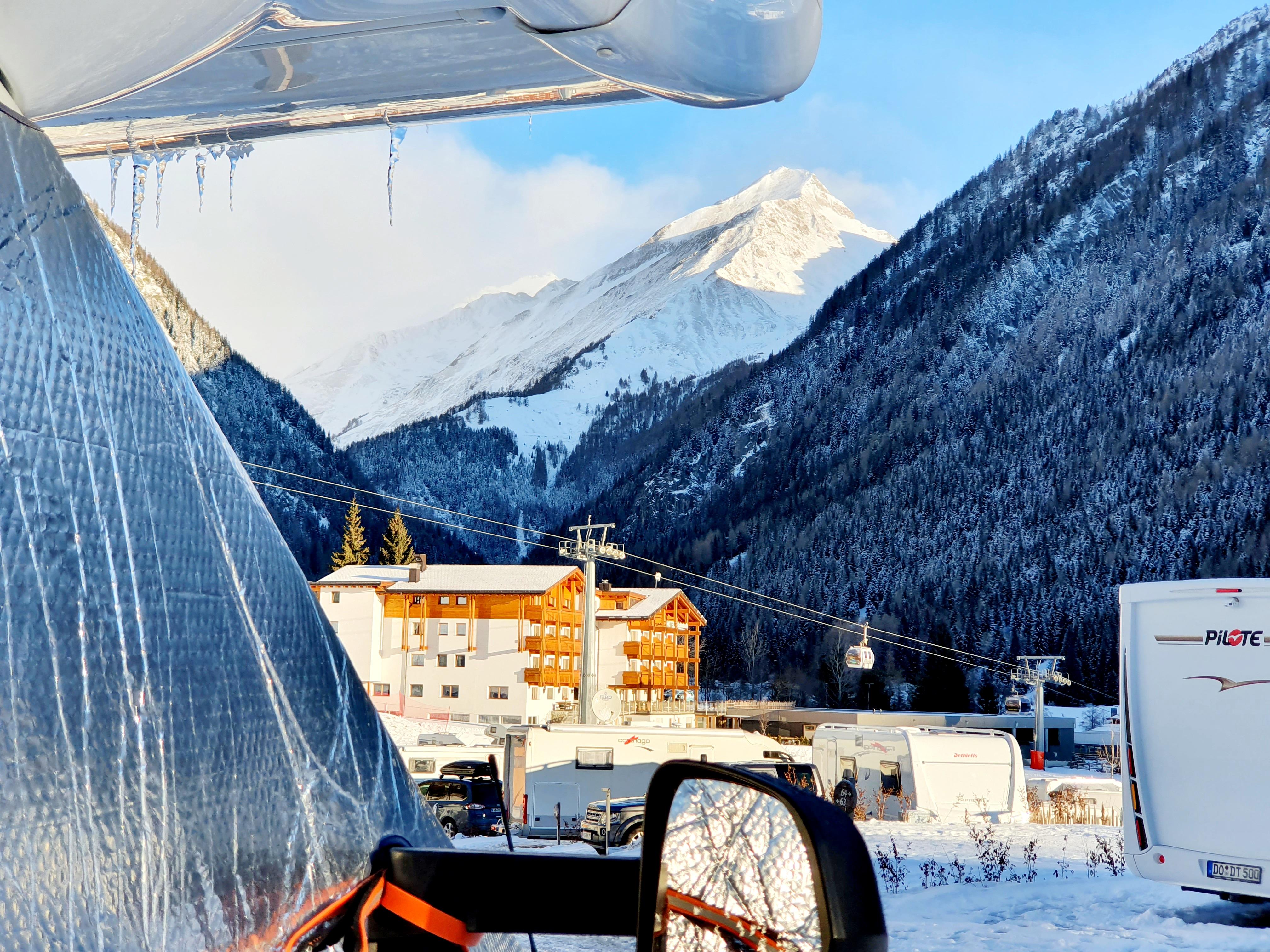 Es ist bitter kalt geworden - eine Thermohülle schützt das Fahrerhaus vor dem Auskühlen. Im Hintergrund sieht man den Lift mit seinen Gondeln.