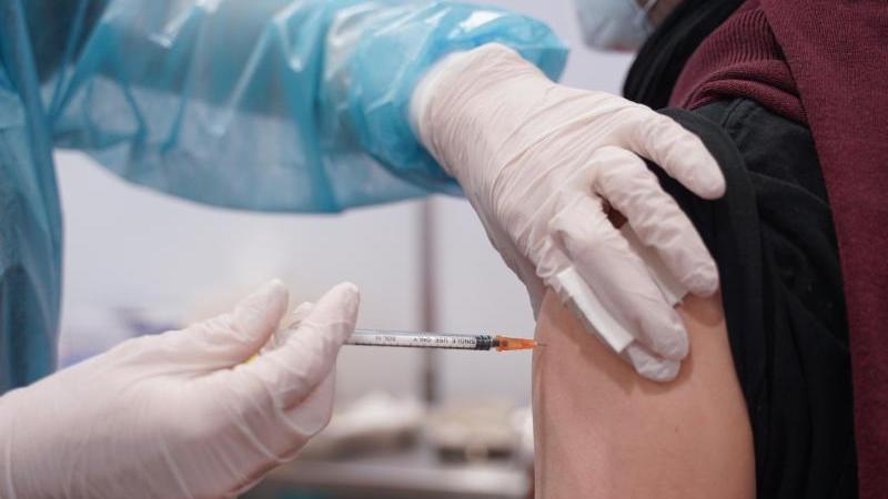 Ein junger Mann wird mit einer Booster-Dosis des Impfstoffs von Moderna geimpft. Ein junger Mann wird mit einer Booster-Dosis des Impfstoffs von Moderna geimpft.