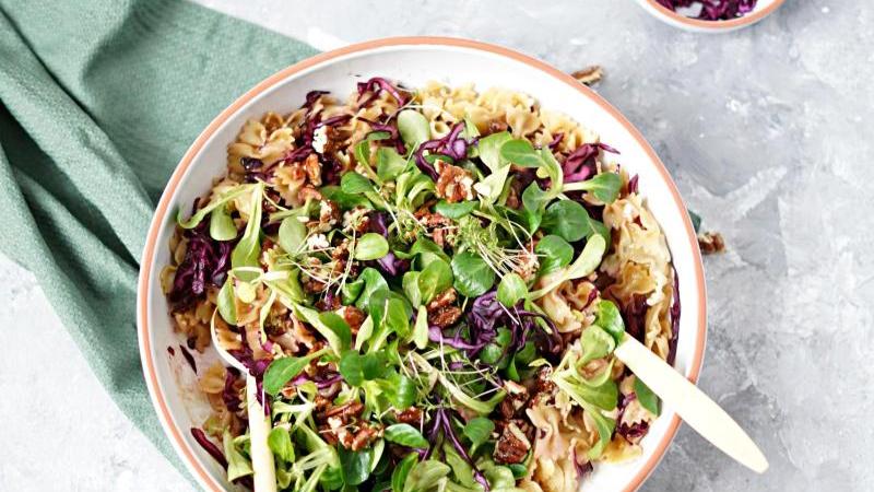 Grüne Blätter des Feldsalats und lila Rotkohl-Streifen bringen Farbe in den Nudelsalat, karamellisierte Nüsse knackige Struktur. Grüne Blätter des Feldsalats und lila Rotkohl-Streifen bringen Farbe in den Nudelsalat, karamellisierte Nüsse knackige Struktur.