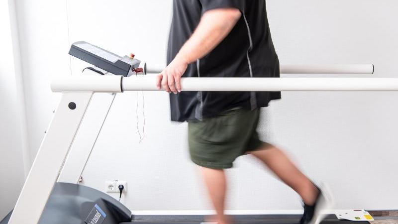 Ein Mann trainiert an einem Laufband, um seine Ausdauer wieder zu stärken. Long-Covid-Kranke sind nach aktuellen Erfahrungen aus der Reha mit ganz unterschiedlichen Symptomen konfrontiert.