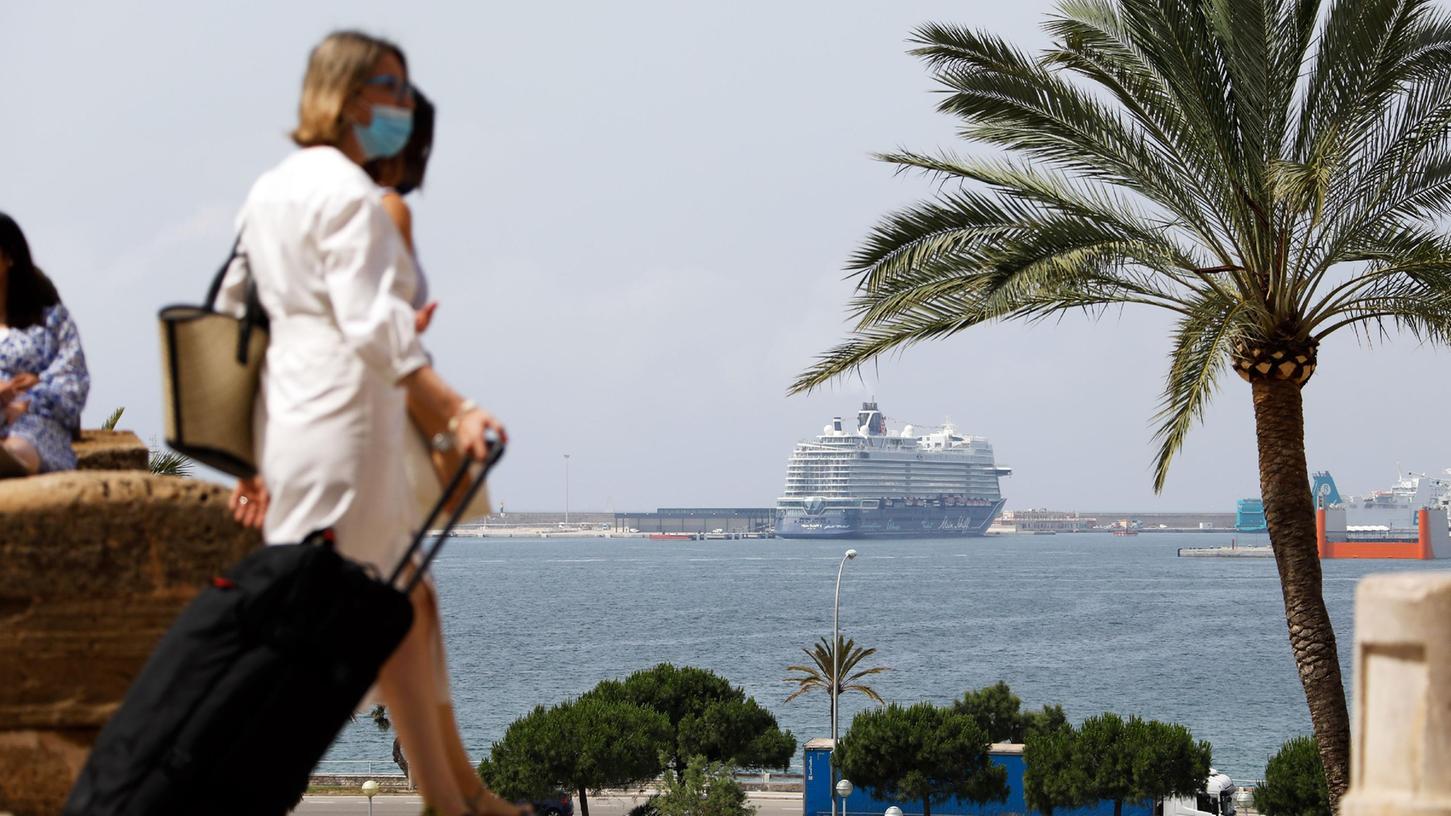Viele zögern, doch diese Passagiere trauen sich: Am Terminal von Palma de Mallorca machen sie sich auf den Weg zu ihrem Kreuzfahrtschiff.