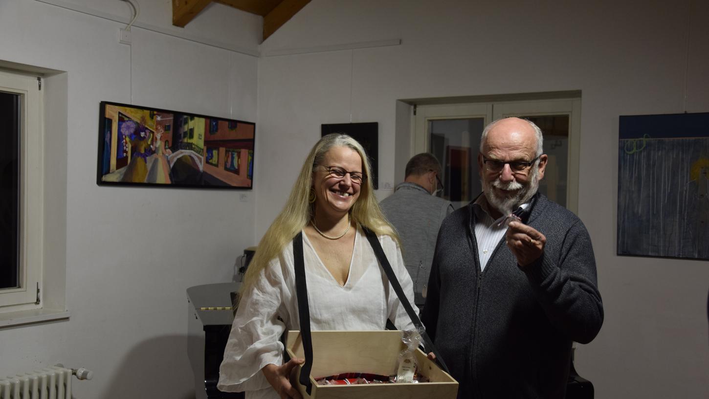Kathrin Koll verteilt als „wandelndes Kunstwerk“ Schokolade an den ersten Vorsitzenden des Themenkunstvereins Ernst Klier.