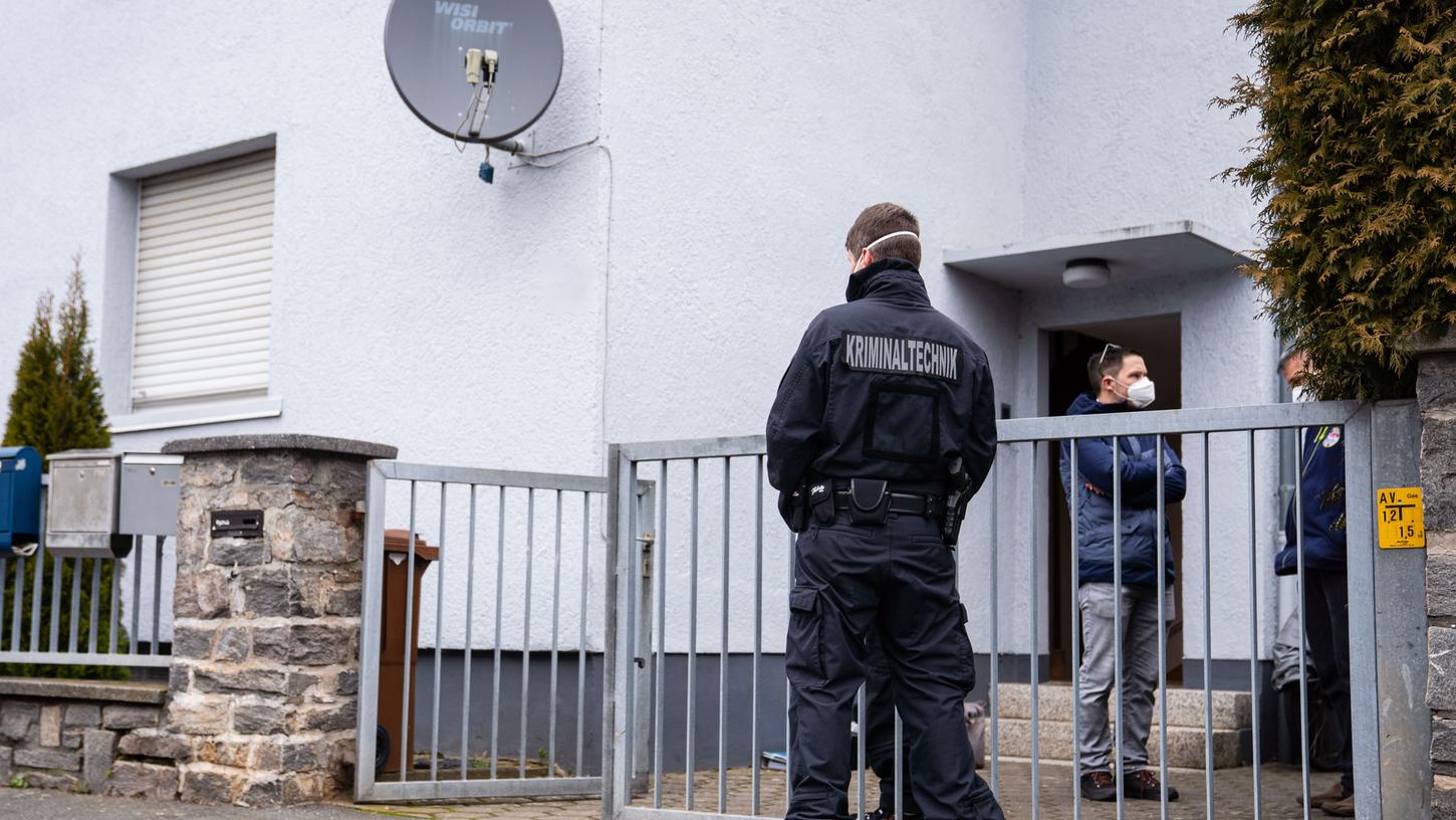 Polizeibeamte der Kriminaltechnik stehen vor einem Haus, in dem zwei tote Kinder entdeckt worden sind.