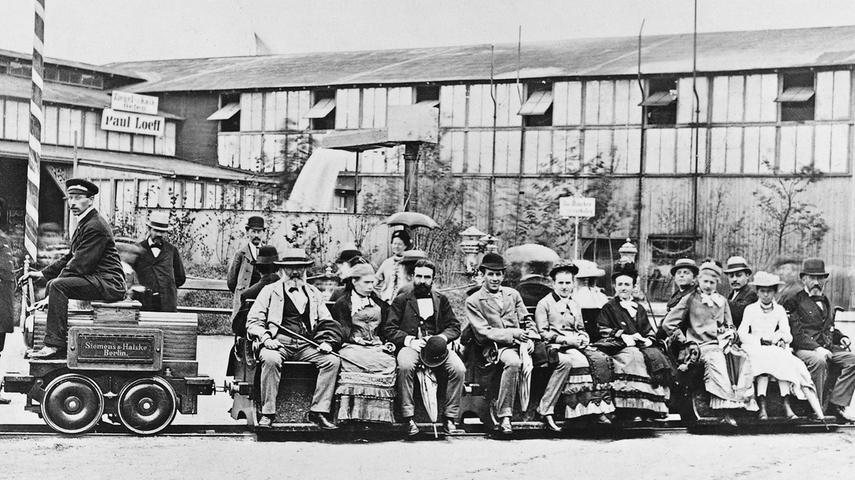 Ein großer Prestigeerfolg gelingt Werner Siemens im Jahr 1879: Auf der Gewerbeausstellung in Berlin präsentiert er die erste elektrische Lokomotive der Welt. 1888 wird er geadelt und darf sich seitdem Werner von Siemens nennen.