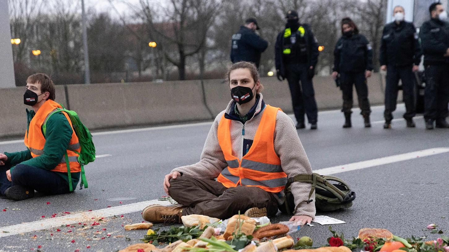 Klimaaktivisten der Gruppe "Aufstand der letzten Generation" sitzen auf der Fahrbahn der Autobahn A100 vor der Ausfahrt Beusselstrasse, um gegen Lebensmittelverschwendung zu protestieren.