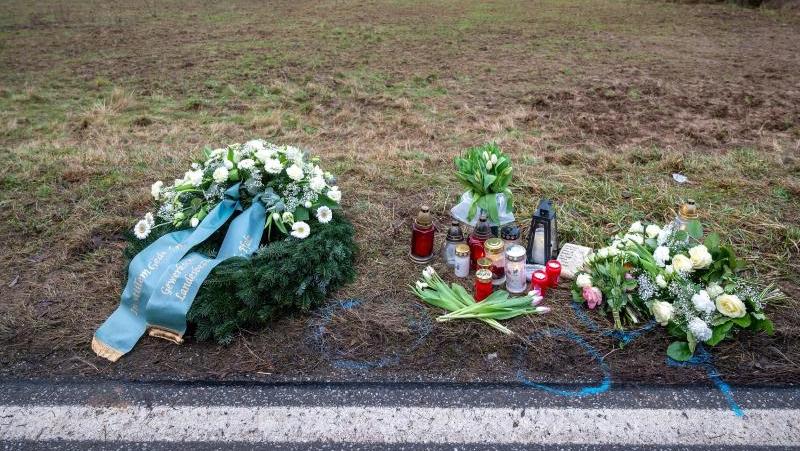 Bei einer Verkehrskontrolle wurden zwei Polizisten erschossen. Ein Kranz sowie Blumen und Kerzen liegen am Tatort an der Kreisstraße 22 bei Ulmet in Rheinland-Pfalz.