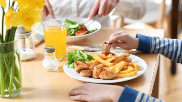 Ein Teller mit Chicken-Nuggets und Pommes auf einem Tisch.