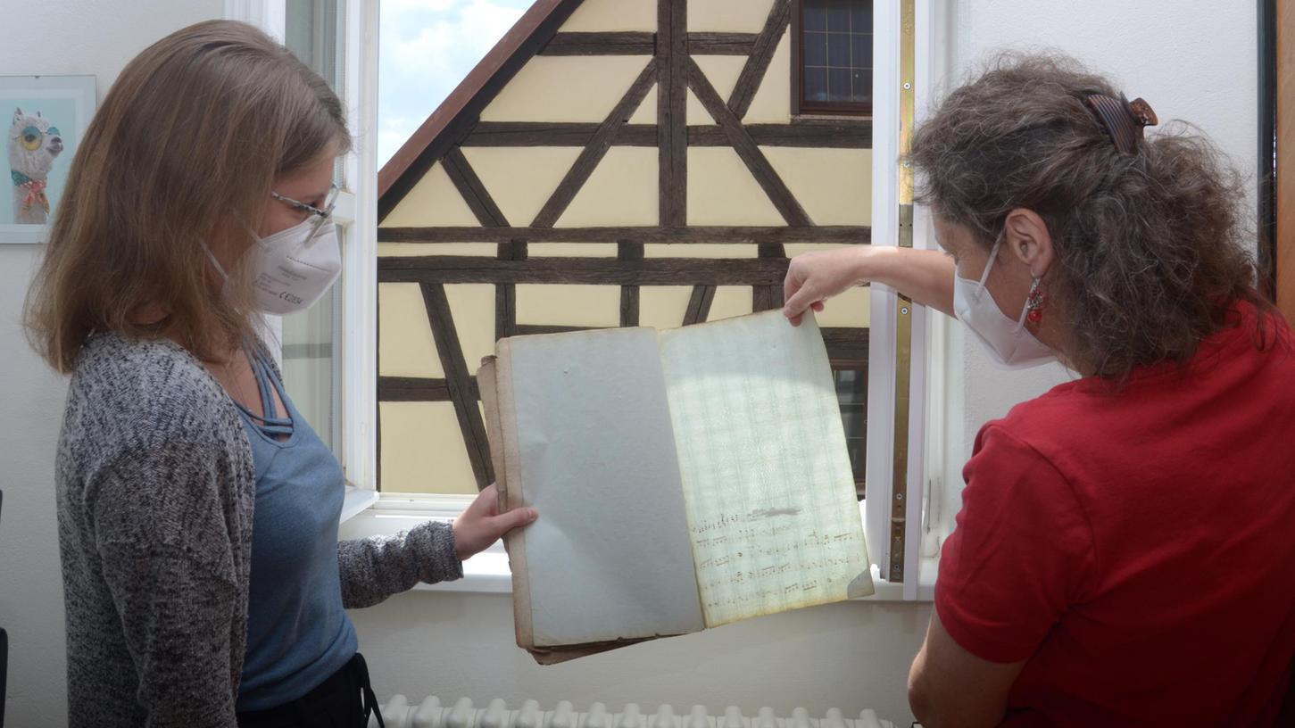 Forschungsstellenleiterin Dr. Heidi Christ (rechts) und Lena Grastat betrachten eine alte Notenhandschrift. Foto: Günter Blank (Foto: gb)
