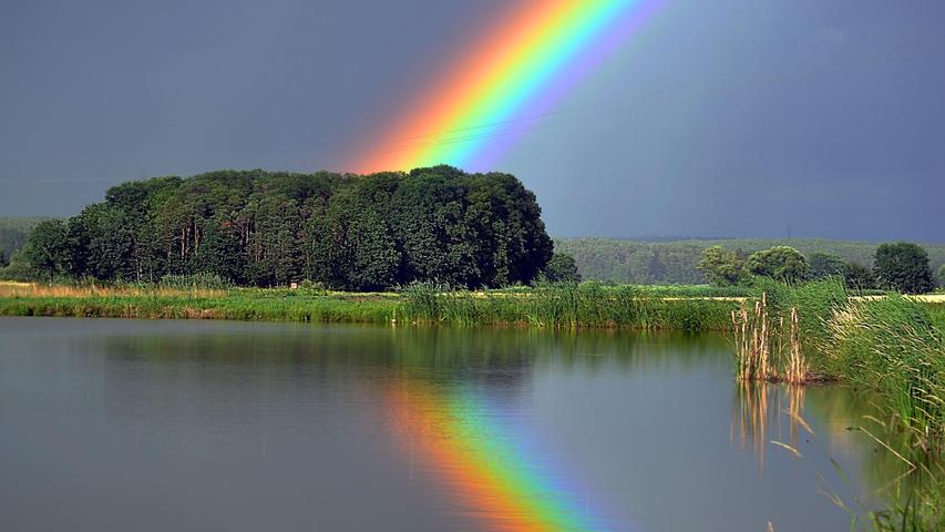 Buntes Spektakel: Ein farbenprächtiger Regenbogen überspannt nach einem Regenschauer das Mohrhofgebiet bei Biengarten im Aischgrund.
