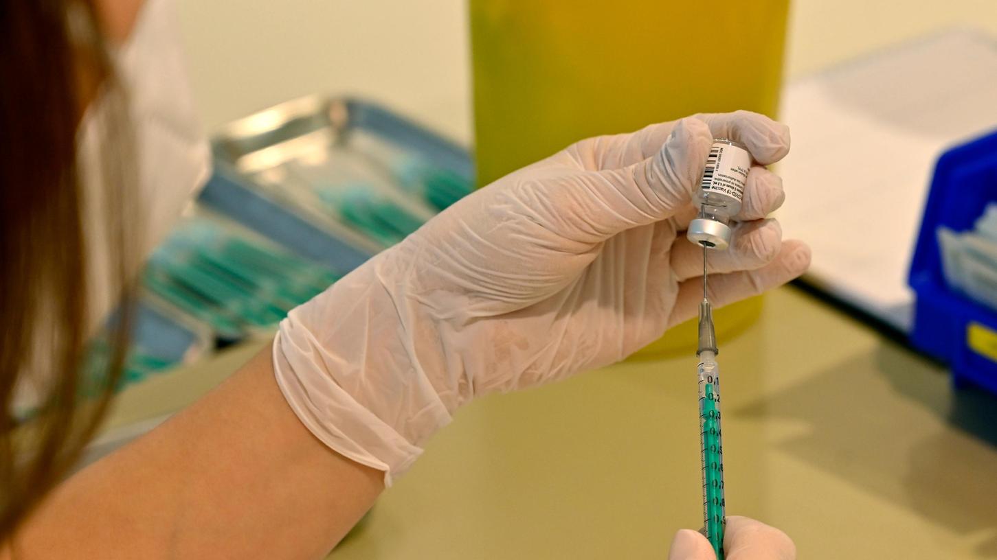 Eine medizinische Mitarbeiterin zieht die Spritzen zum Impfen auf. Die Impfung schützt nach wie vor vor schweren Verläufen - auch bei Omikron.