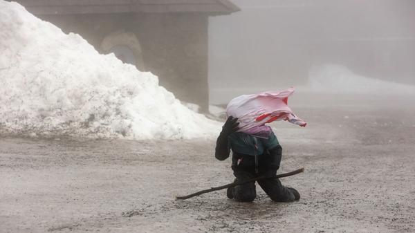 Ein Wanderer kämpft auf dem Brocken gegen starke Windböen