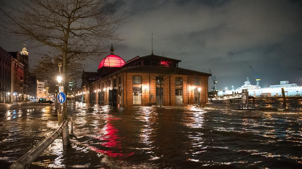 Hamburg: Der Fischmarkt mit der Fischauktionshalle ist am Morgen während einer Sturmflut beim Hochwasser der Elbe überschwemmt. Der Hamburger Fischmarkt ist am frühen Donnerstagmorgen erneut überflutet worden. «Am Pegel St. Pauli wurde gegen 5.00 Uhr ein Wert von 1,98 Meter über dem mittleren Hochwasser (MHW) gemessen», sagte ein Sprecher des Sturmflutwarndienstes des Bundesamts für Seeschifffahrt und Hydrographie (BSH) in Hamburg.