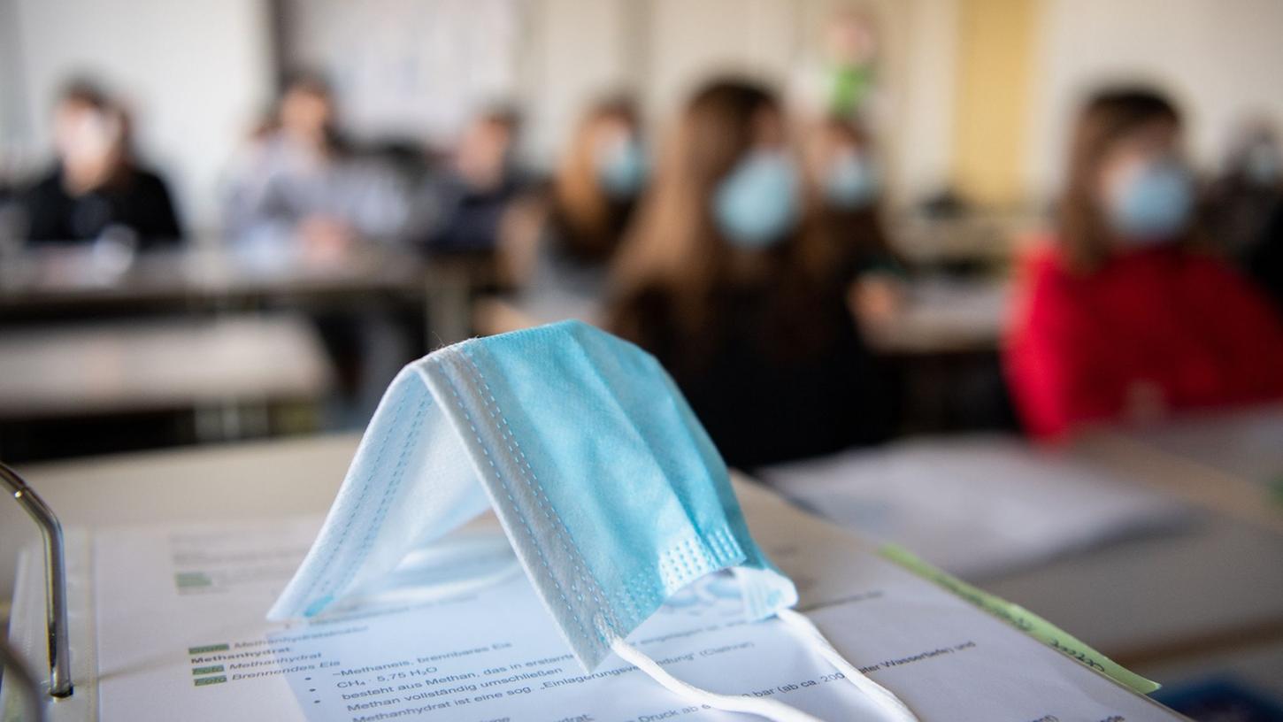 An Bayerns Schulen gilt auch im Unterricht weiter die Maskenpflicht. Die Staatsregierung lässt Zweifel daran aufkommen, ob sich das so schnell ändert. 