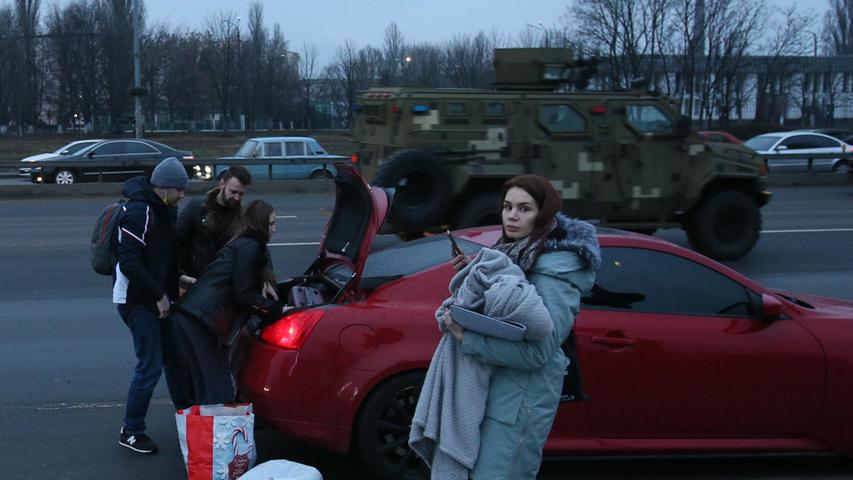 In Kiew packen junge Menschen ihre Sachen in ein Auto, um vor dem Krieg zu fliehen.