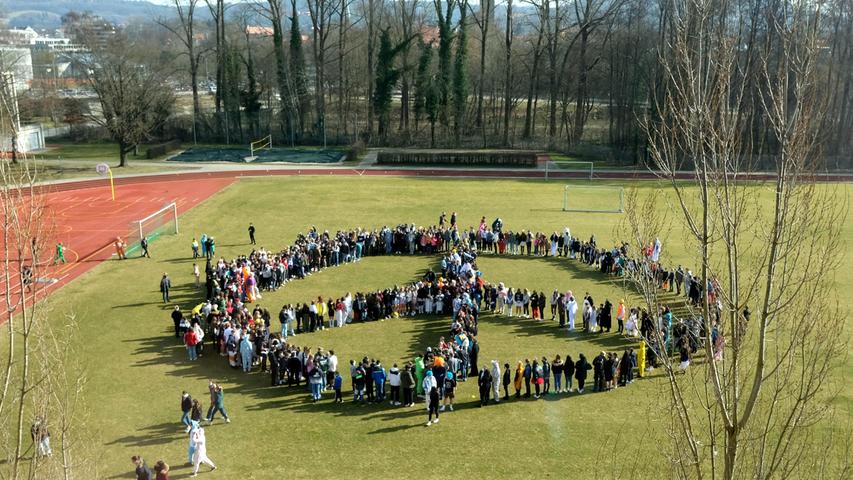 Zum Abschluss setzten die Schülerinnen und Schüler ein Signal  für den Frieden: Sie formten ein großes Peace-Zeichen.  
