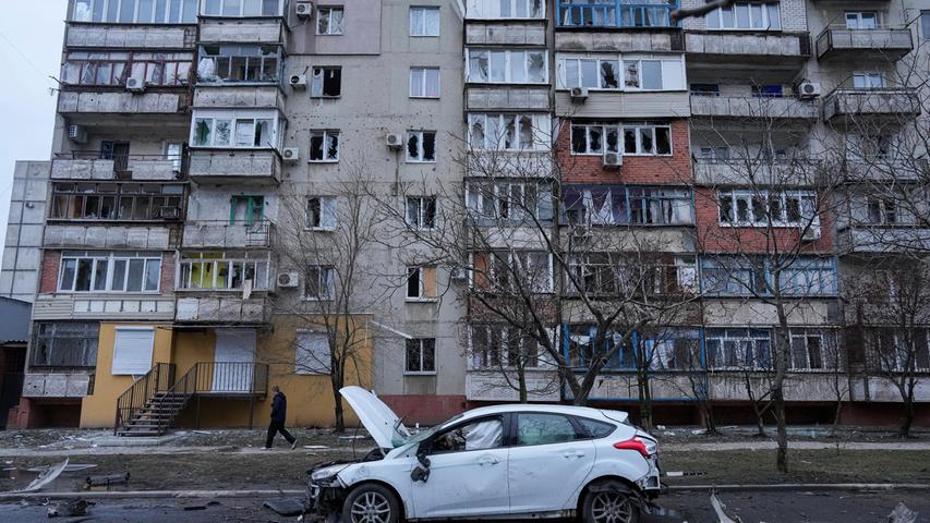 Ein beschädigtes Auto steht nach russischem Beschuss auf einer Straße in Mariupol.