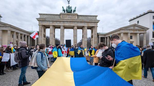 Demonstranten mit Nationalflaggen der Ukraine am Brandenburger Tor in Berlin (Foto vom 24.02.2022). Wenige Stunden nach