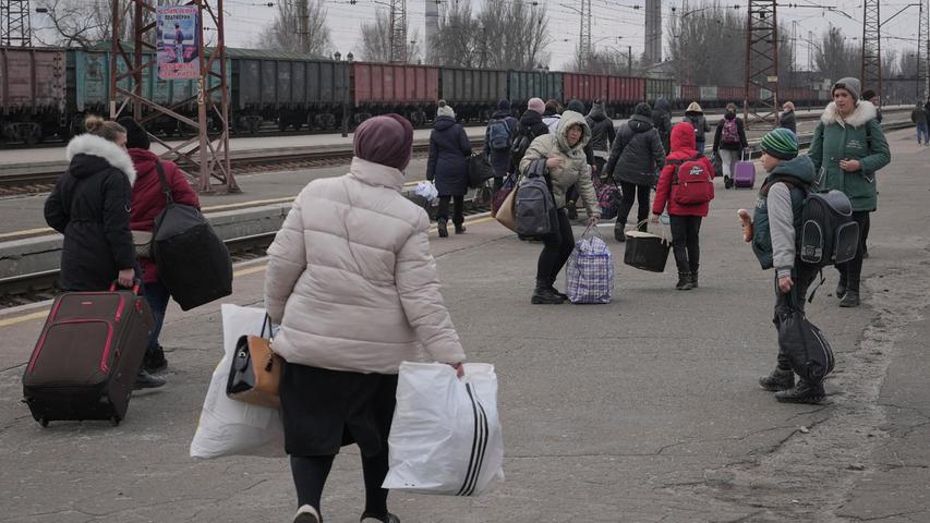 Menschen, die auf einen nach Kiew fahrenden Zug warten, verteilen sich auf einem Bahnsteig in Kostiantynivka in der Region Donezk in der Ostukraine.