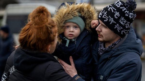 Vlad (r) übergibt den zweijährigen Sohn Danya seiner Mutter Tatiana zum Abschied an einem Busbahnhof, bevor sie Kiew verlässt.