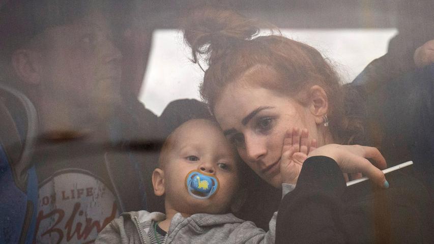 Eine Frau hält ihr Baby in einem Bus, während sie Kiew verlässt.