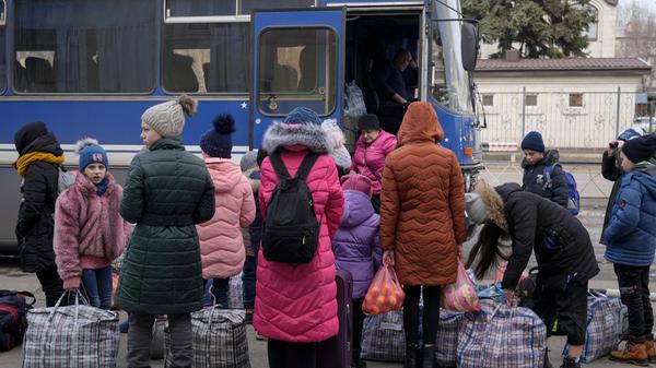 Kinder warten mit Taschen und ihren Habseligkeiten auf dem Bahnhof, um Kostiantynivka in der Region Donezk im Osten der Ukraine zu verlassen.