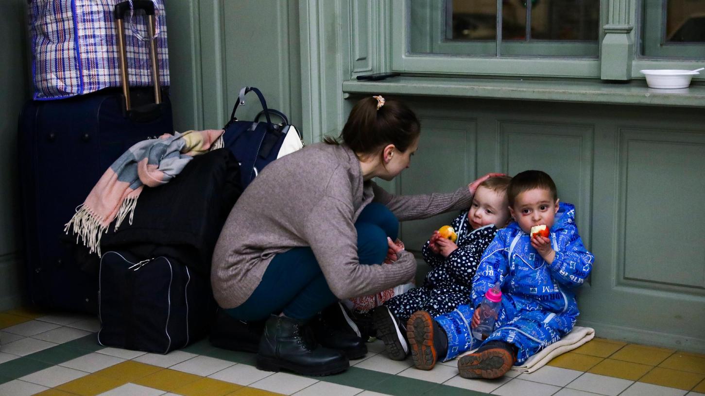 In Polen sind die ersten Flüchtlinge aus der Ukraine bereits angekommen. Eine Mutter und ihre Kinder warten in einem Aufenthaltsgebäude eines Bahnhofs in Przemysl.