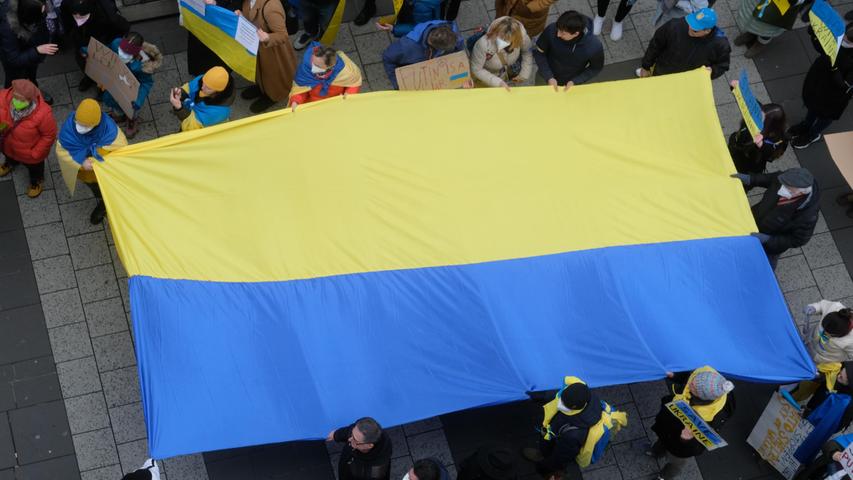 Dementsprechend haben sich sowohl viele Ukrainer als auch Russen vor Ort eingefunden.Mehrere Teilnehmerinnen und Teilnehmer des Protests zogen mit einer großen ukrainischen Flagge durch die Menge.