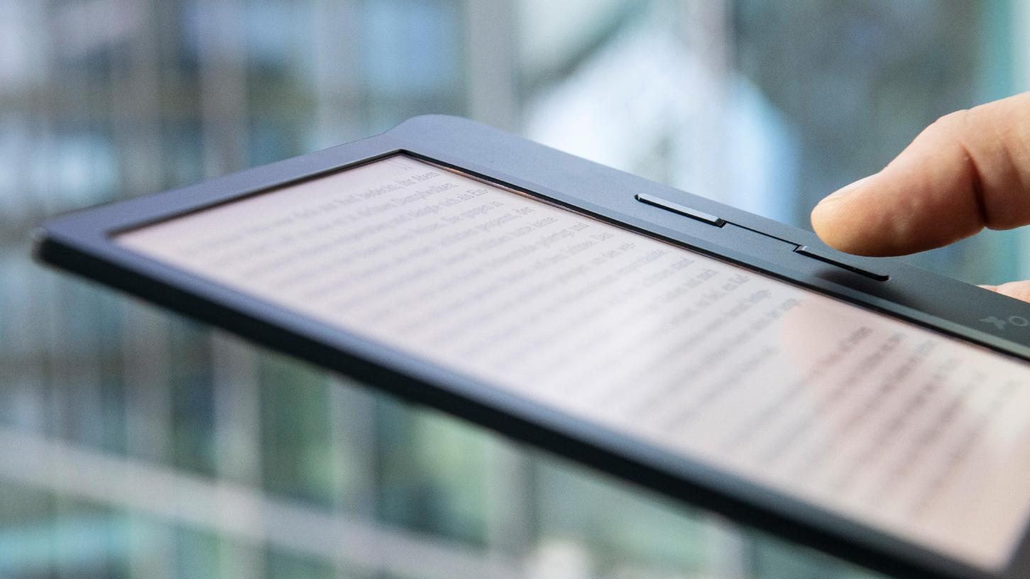 Ein Mann liest ein E-Book.
Ein Mann liest ein E-Book.