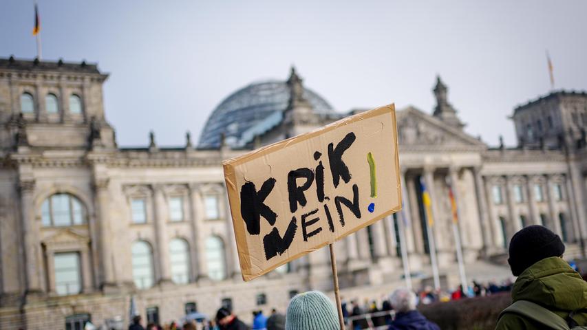 Eine Teilnehmerin hält das Plakat ihrer Kinder mit der Aufschrift ·Krik Nein· vor dem Reichstagsgebäude am Rande der Demonstration gegen den Krieg in der Ukraine.