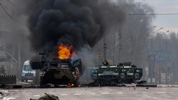 Ein gepanzerter Mannschaftswagen brennt und beschädigte Nutzfahrzeuge stehen nach Kämpfen in Charkiw am Sonntag auf einer Straße. Nach ukrainischen Angaben liefern sich in der Großstadt im Osten russische und ukrainische Truppen Straßenkämpfe. Die Angreifer seien ins Zentrum der Stadt mit etwa 1,5 Millionen Einwohnern gelangt.