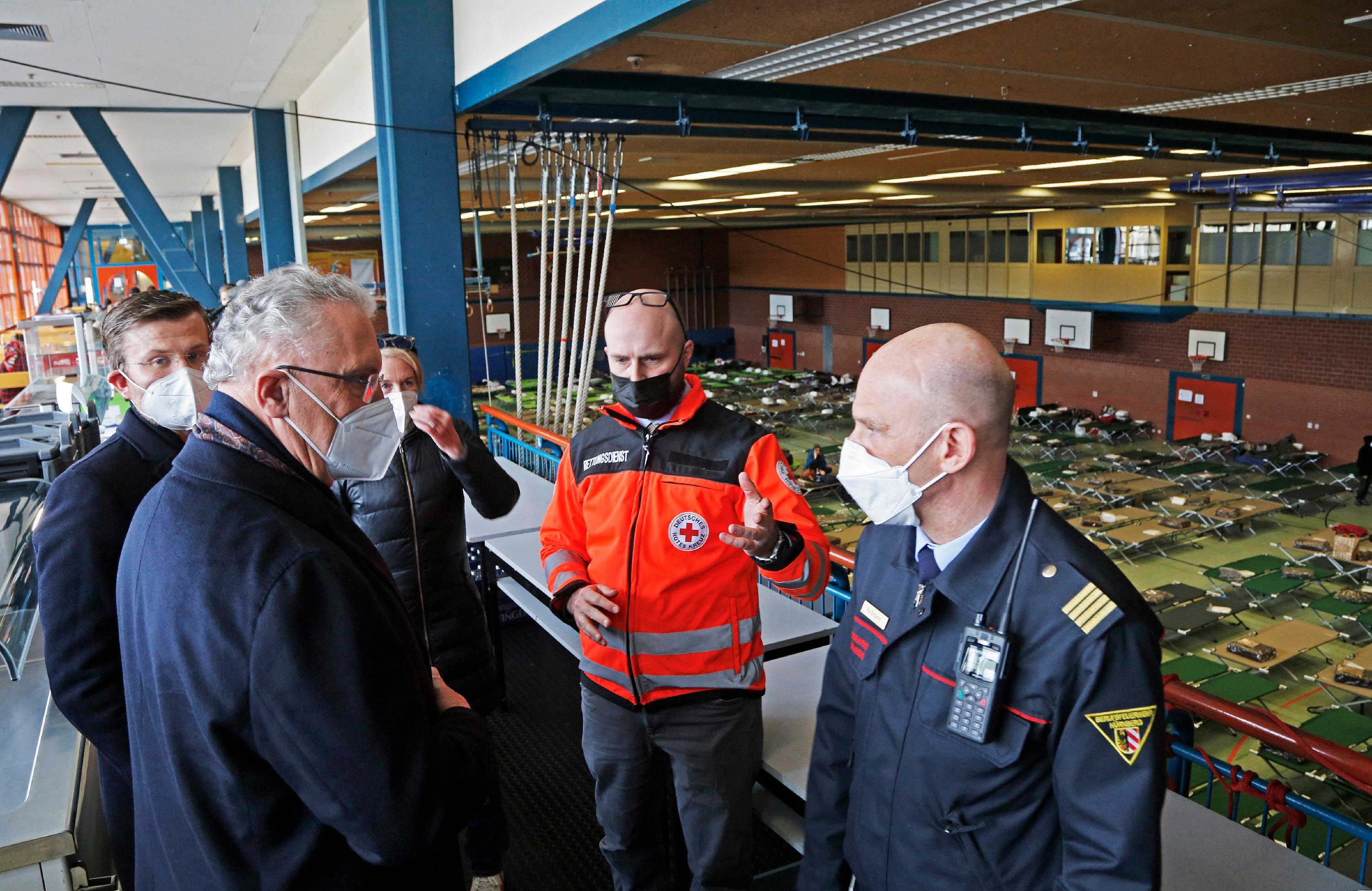 Nürnbergs Oberbürgermeister Marcus König (l.) und Bayerns Innenminister Joachim Herrmann (2.v.l.) machten sich vor Ort ein Bild von der Lage. Hier sprechen sie mit Hans-Peter Reißmann von der Berufsfeuerwehr Nürnberg (r.)und Thilo Könicke vom Roten Kreuz.