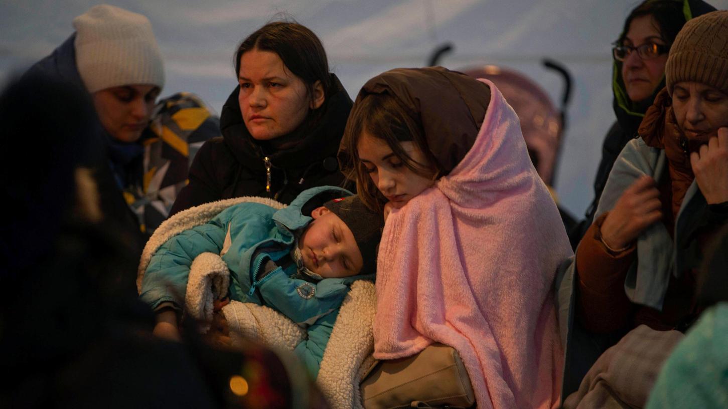 Flüchtlinge, meist Frauen mit Kindern, ruhen sich in einem Zelt aus, nachdem sie am Sonntag am Grenzübergang in Medyka, Polen, angekommen sind. (Symbolbild).
