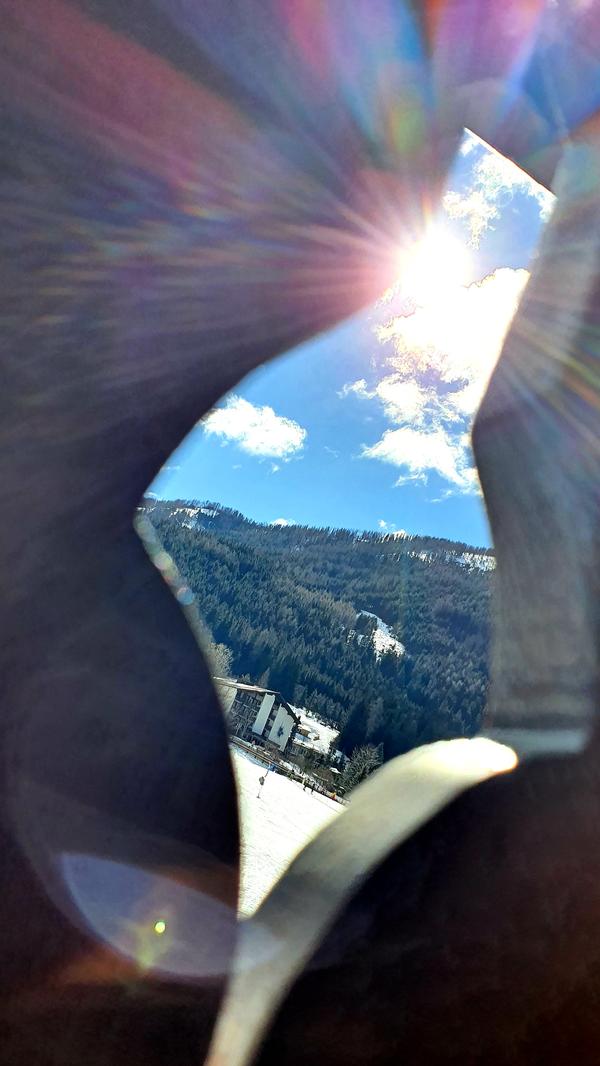 Endlich in den Bergen angekommen - beim Blick durch die Balkonbrüstung blitzt die Sonne über der Piste. Die spannende Reisereportage zu dieser Bildergalerie lesen Sie hier.