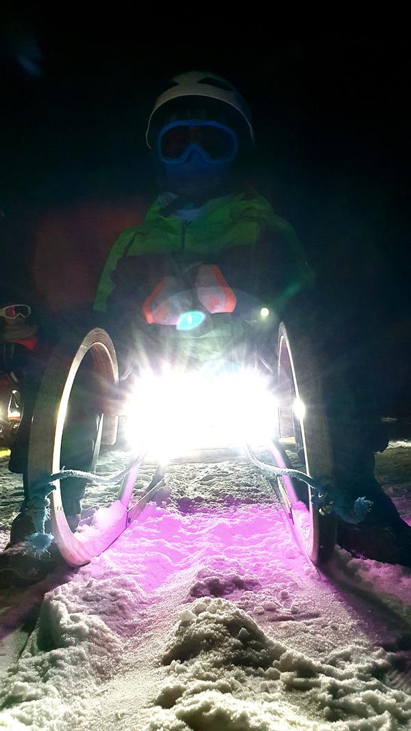 Lampen unter den Rodeln leuchten nachts die Schlittenbahn aus.