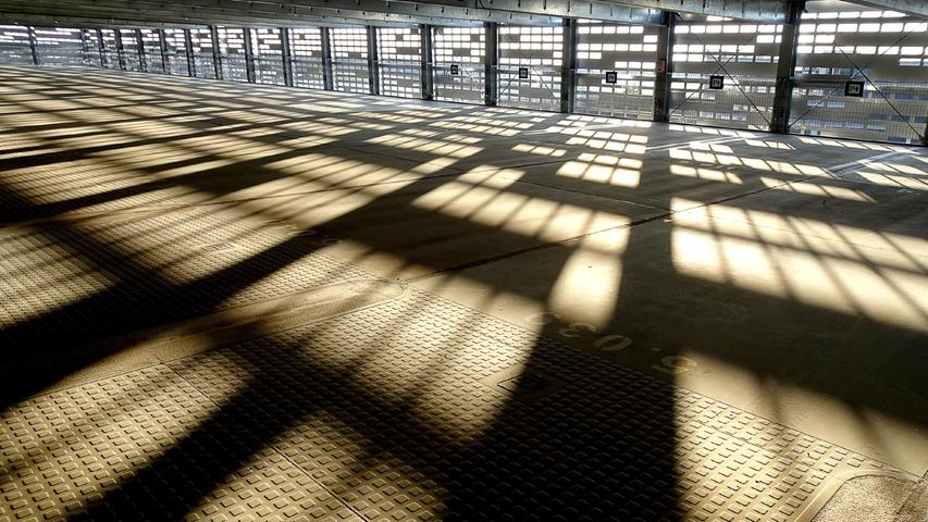 In einer leeren Etage des Parkhauses 4 am Flughafen zeichnet die Sonne ein interessantes Schattenmuster auf den Boden.