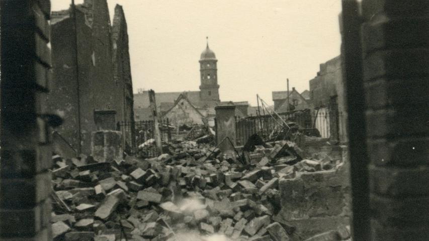 1943 entstand dieser Schnappschuss vom Hadergäßchen aus, der den neubarocken Kirchturm scheinbar unversehrt zwischen ausgebrannten Häuserruinen zeigt.  