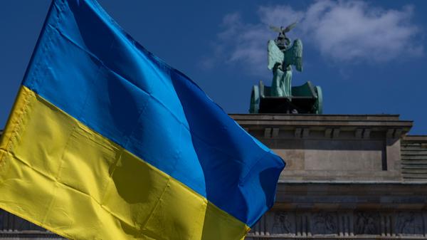 Die Fahne der Ukraine weht bei einer Protestaktion gegen den russischen Krieg in der Ukraine am Brandenburger Tor.