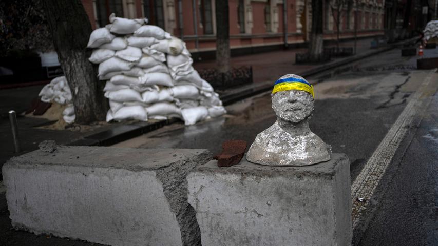 Ukraine, Kiew: Eine Skulptur mit einem Stirnband in den Farben der ukrainischen Flagge steht an einem Kontrollpunkt. Seit über einem Monat herrscht in der Ukraine Krieg. Die Kämpfe dauern unvermindert an. Auf der Flucht vor den russischen Truppen haben Millionen Menschen das Land verlassen.