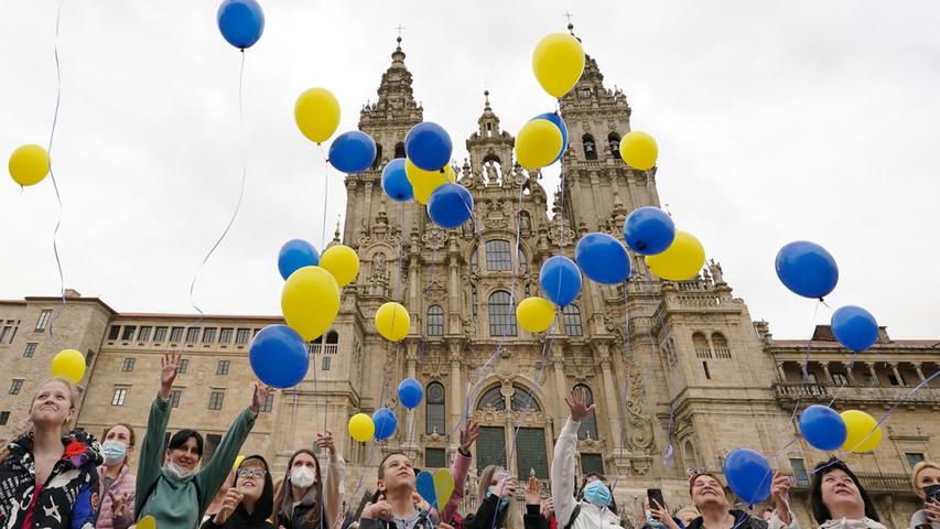 Spanien, Santiago De Compostela, A Coruña: Menschen lassen auf dem Obradoiro-Platz Luftballons in den Farben der ukrainischen Flagge in die Luft steigen, um das Ende des Krieges in der Ukraine zu fordern. Die Veranstaltung, an der auch ukrainische Flüchtlinge teilnahmen, wurde von einem Forschungszentrum der Universität Santiago de Compostela organisiert. 
