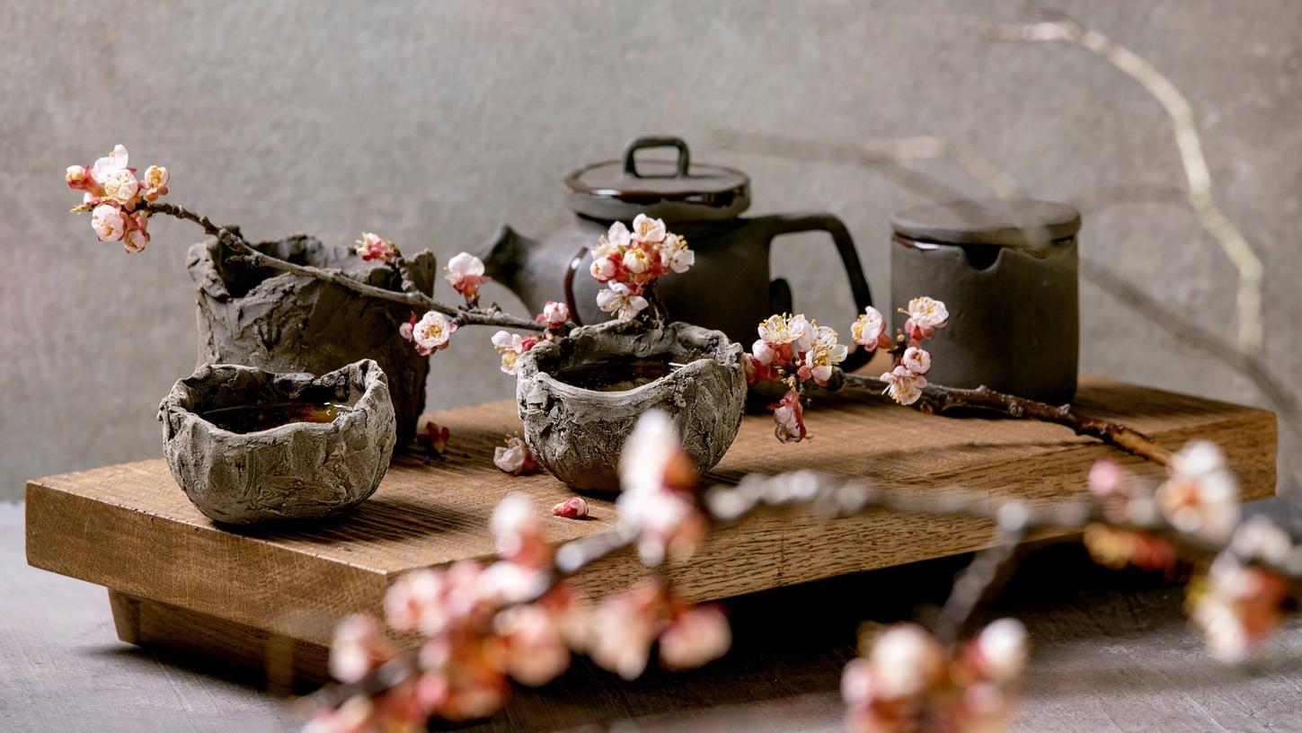 Teetrinken im japanischen Wabi-Sabi-Stil: Nicht glattpoliert, sondern grob, griffig und wie zufällig geformt sind die Tassen des Teeservices.  