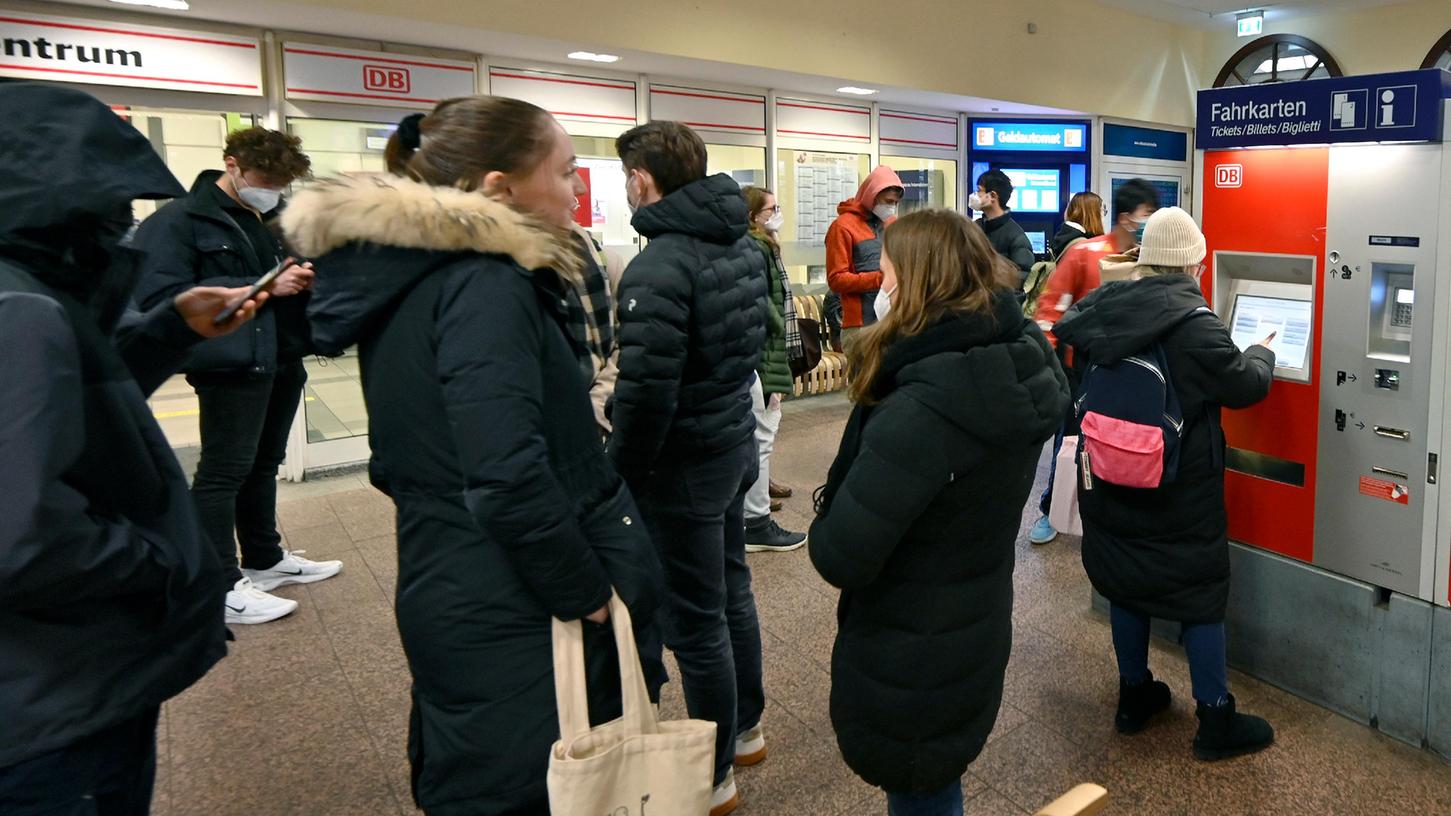 Studierende stehen auf dem Erlanger Bahnhof am Fahrkartenautomaten an.