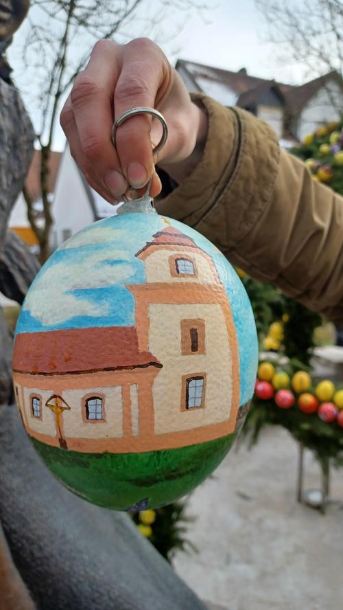 Christina Halbig hat ein neues großes Ei für die Krone gemalt. Es zeigt die Sankt-Walburg-Kirche, deren Weihe sich heuer zum 300. Mal jährt.