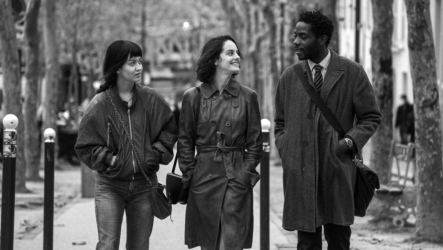 Der attraktive Französischlehrer Camille (Makita Samba) hat leichtes Spiel bei Emilie (Lucie Zhang, li.) und Nora (Noémie Merlant) – zumindest am Anfang. Szene aus Jacques Audiards neuem Film "Wo in Paris die Sonne aufgeht".
Der attraktive Französischlehrer Camille (Makita Samba) hat leichtes Spiel bei Emilie (Lucie Zhang, li.) und Nora (Noémie Merlant) – zumindest am Anfang. Szene aus Jacques Audiards neuem Film "Wo in Paris die Sonne aufgeht".