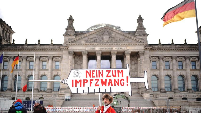 Vor der Abstimmung des Bundestages über eine Corona-Impfpflicht: Ein Demonstrant steht vor dem Reichstagsgebäude mit einem Plakat mit der Aufschrift ·Nein zum Impfzwang!·