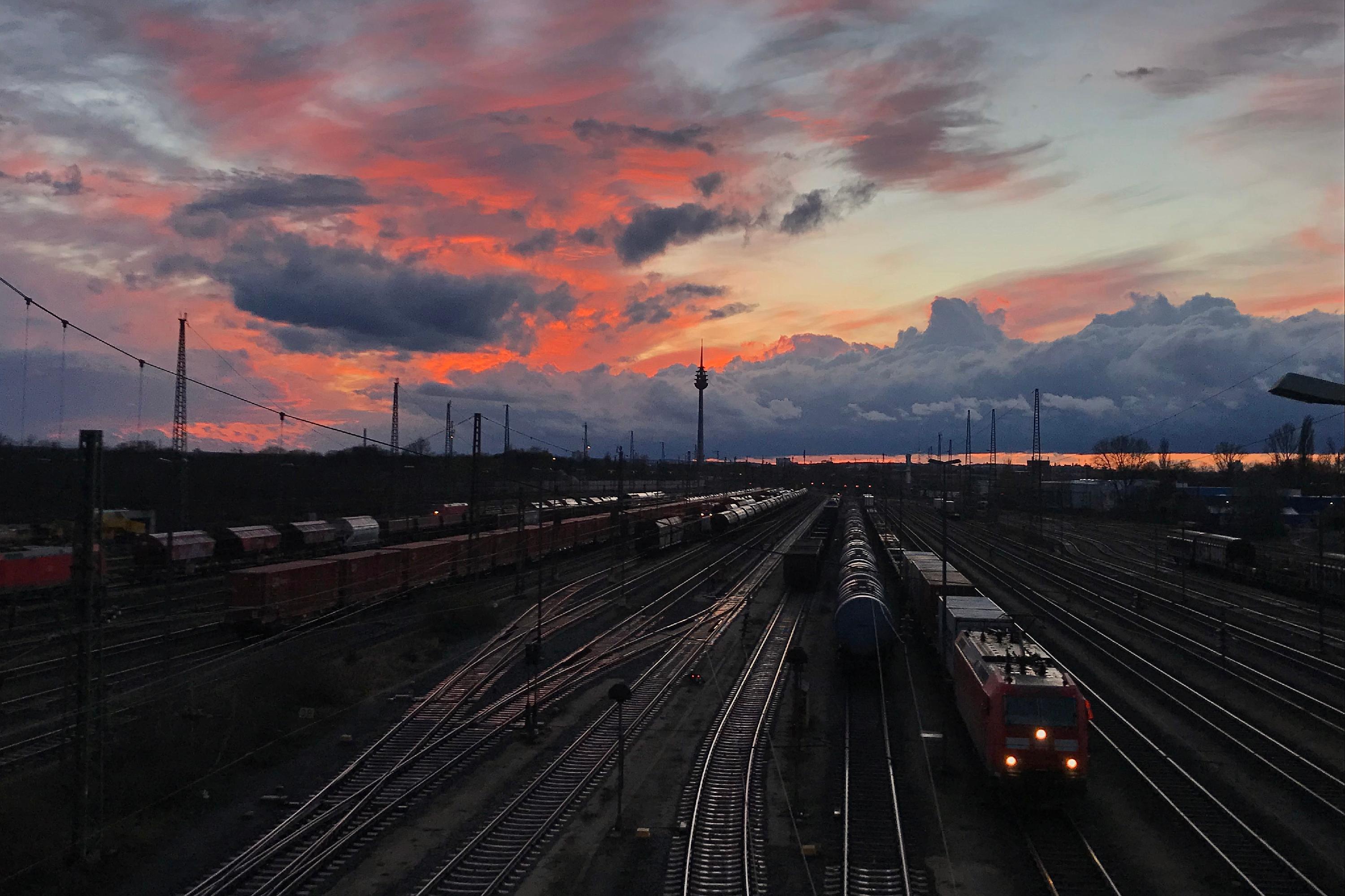 Alpenglühen hinter dem Rangierbahnhof: als würde sich ein Gebirge am Horizont befinden, samt Sonnenuntergang.