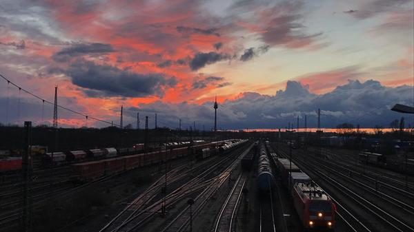 Alpenglühen hinter dem Rangierbahnhof: als würde sich ein Gebirge am Horizont befinden, samt Sonnenuntergang.