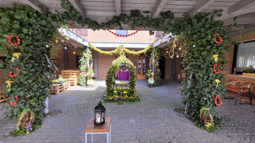 Auch im Nachbarort Boxdorf ist das Atrium der Kirche "Zum guten Hirten" bunt. In der Mitte plätschert ein kleiner Brunnen, aber auch drumherum begrüßen Hase und Osterschmuck die Dorfbewohner.